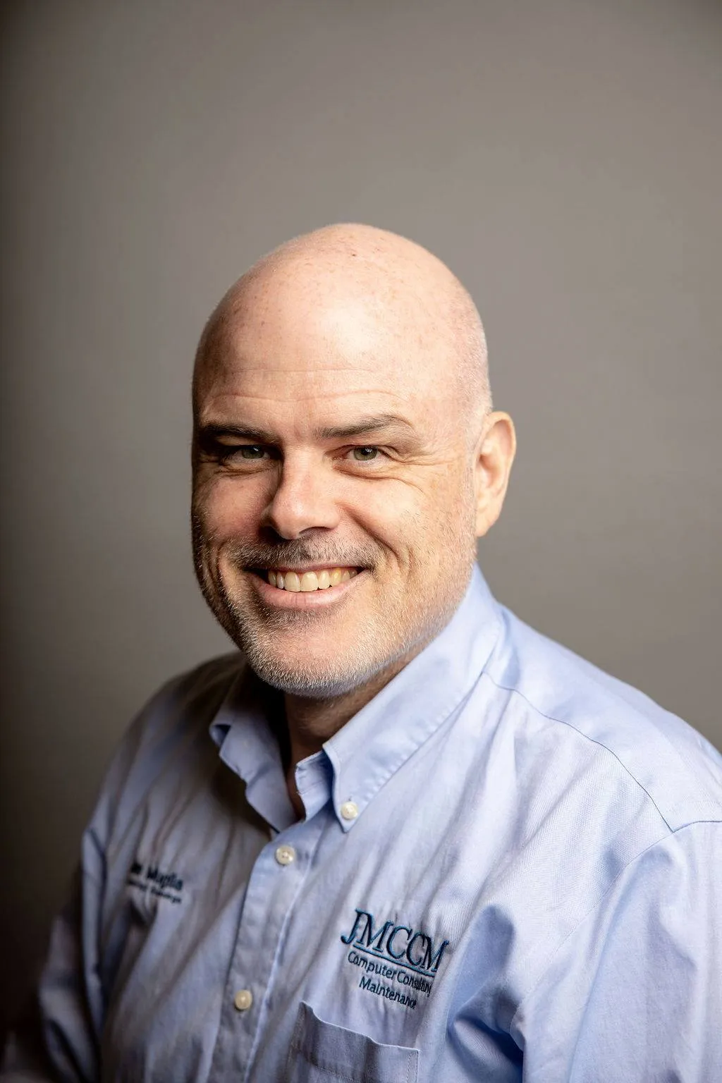A man with a bald head and a blue shirt. - ASCII Group Images