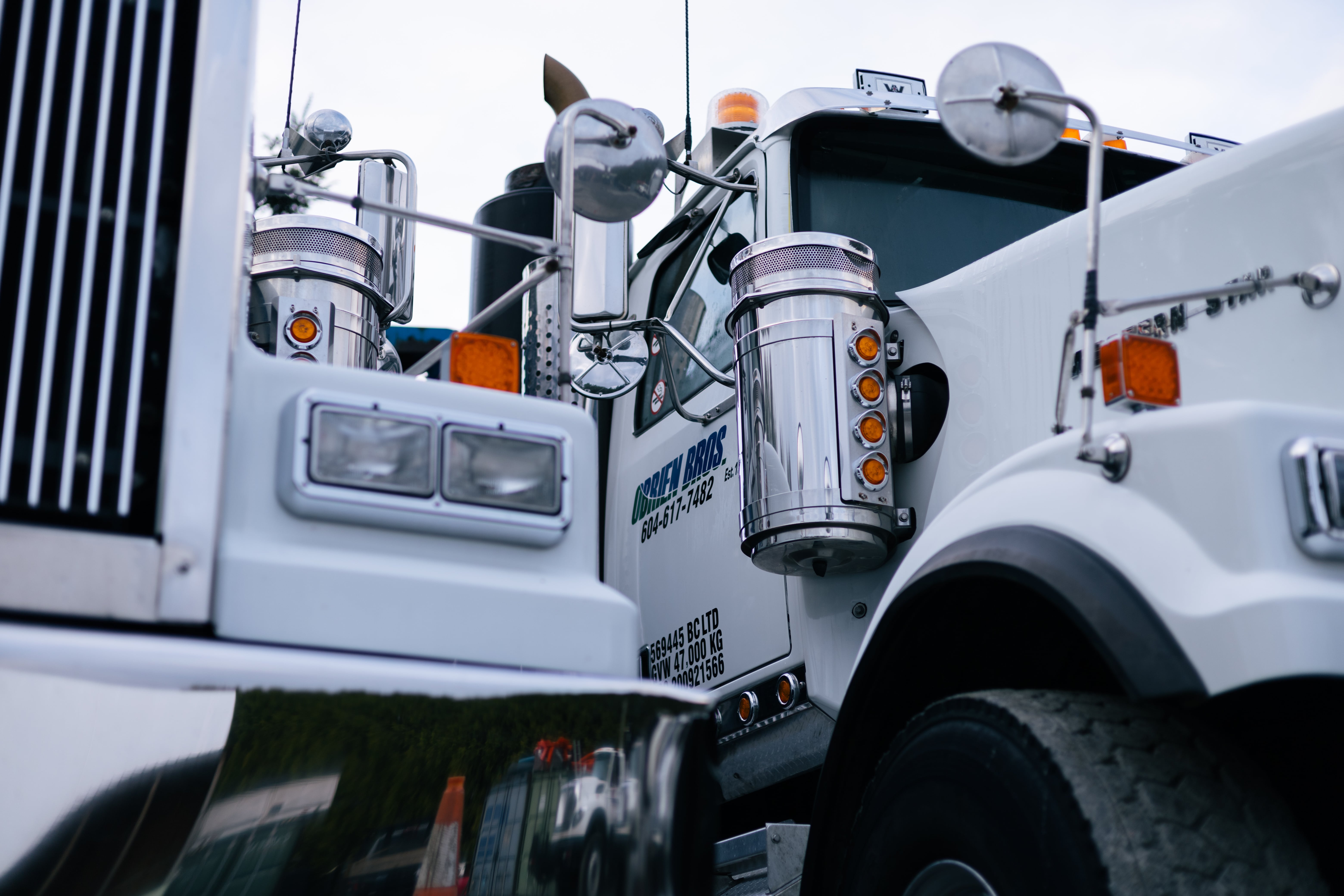Close-up of a Griffin Bros truck with shiny chrome exhausts and bright orange lights.