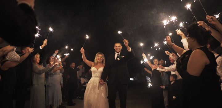  A wedding couple walking down an aisle of sparklers. 