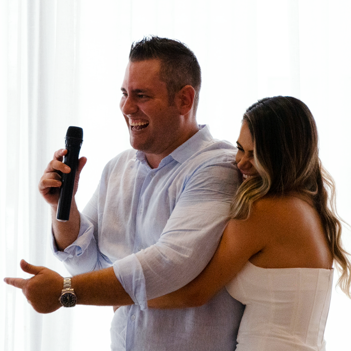 A couple sharing laughter during a wedding speech. 