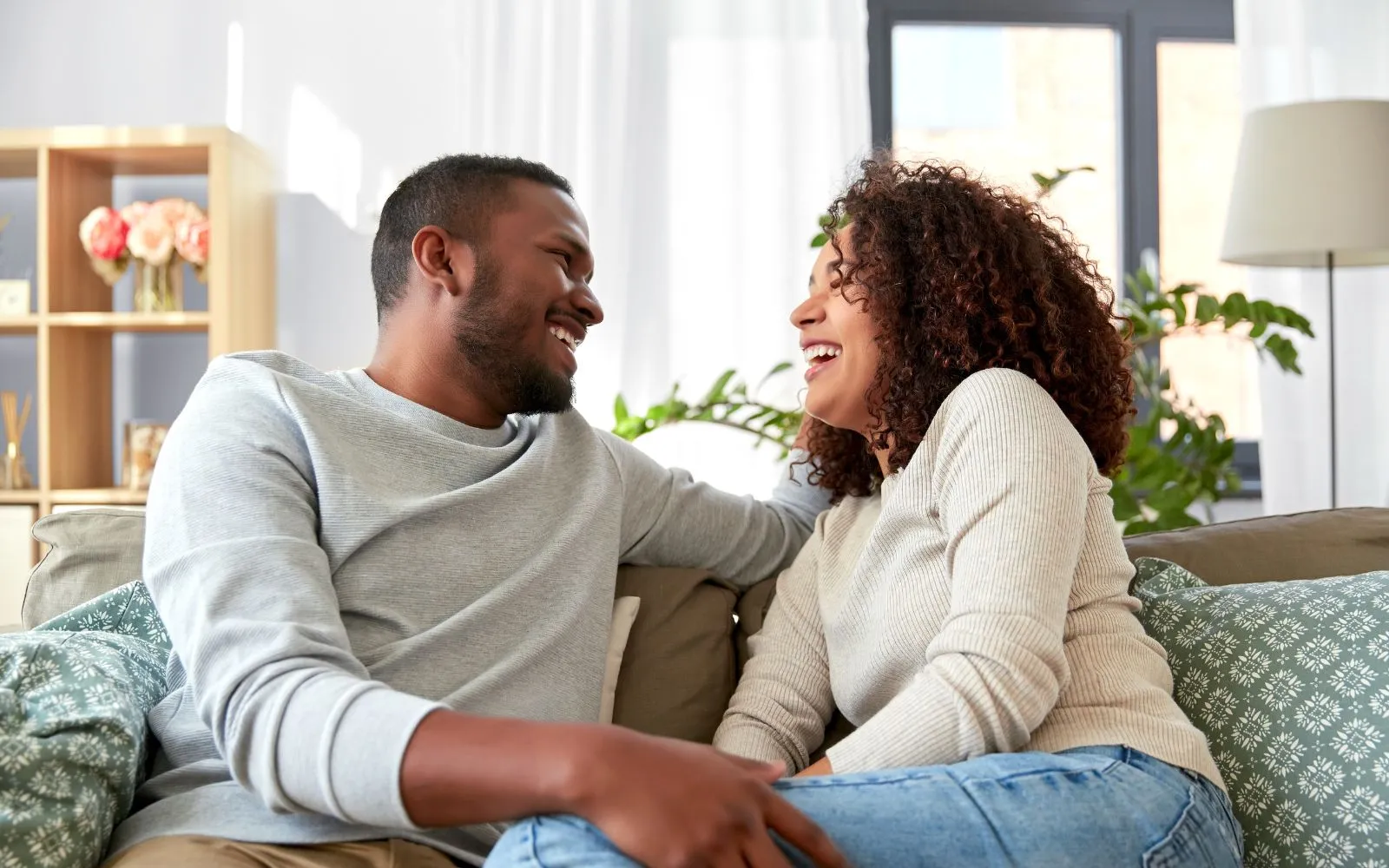 couple sitting on a couch laughing 