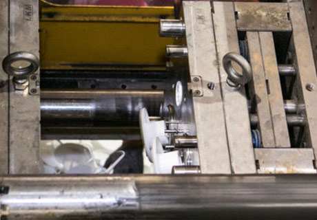 Close-up of industrial machinery with metal components and white plastic gears.