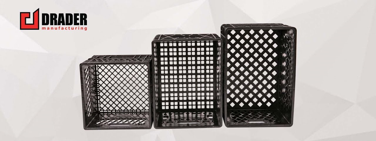 Three black plastic crates of different sizes arranged in a row on a light geometric background, with the Drader Manufacturing logo in the top left corner.