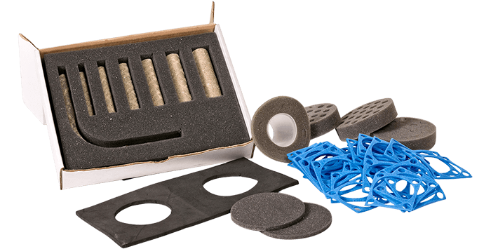 Various foam and rubber gaskets and seals organized next to a white box with foam inserts.