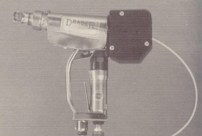 Vintage industrial handheld tool labeled 'DRAPER' with a metal body and attached wires.