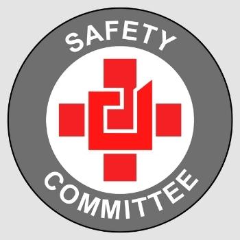 Safety Committee emblem featuring a stylized red cross with interlocking shapes inside a gray circle with white text.