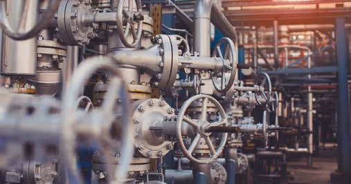 Una red de tuberías metálicas, probablemente de acero inoxidable, domina la composición.