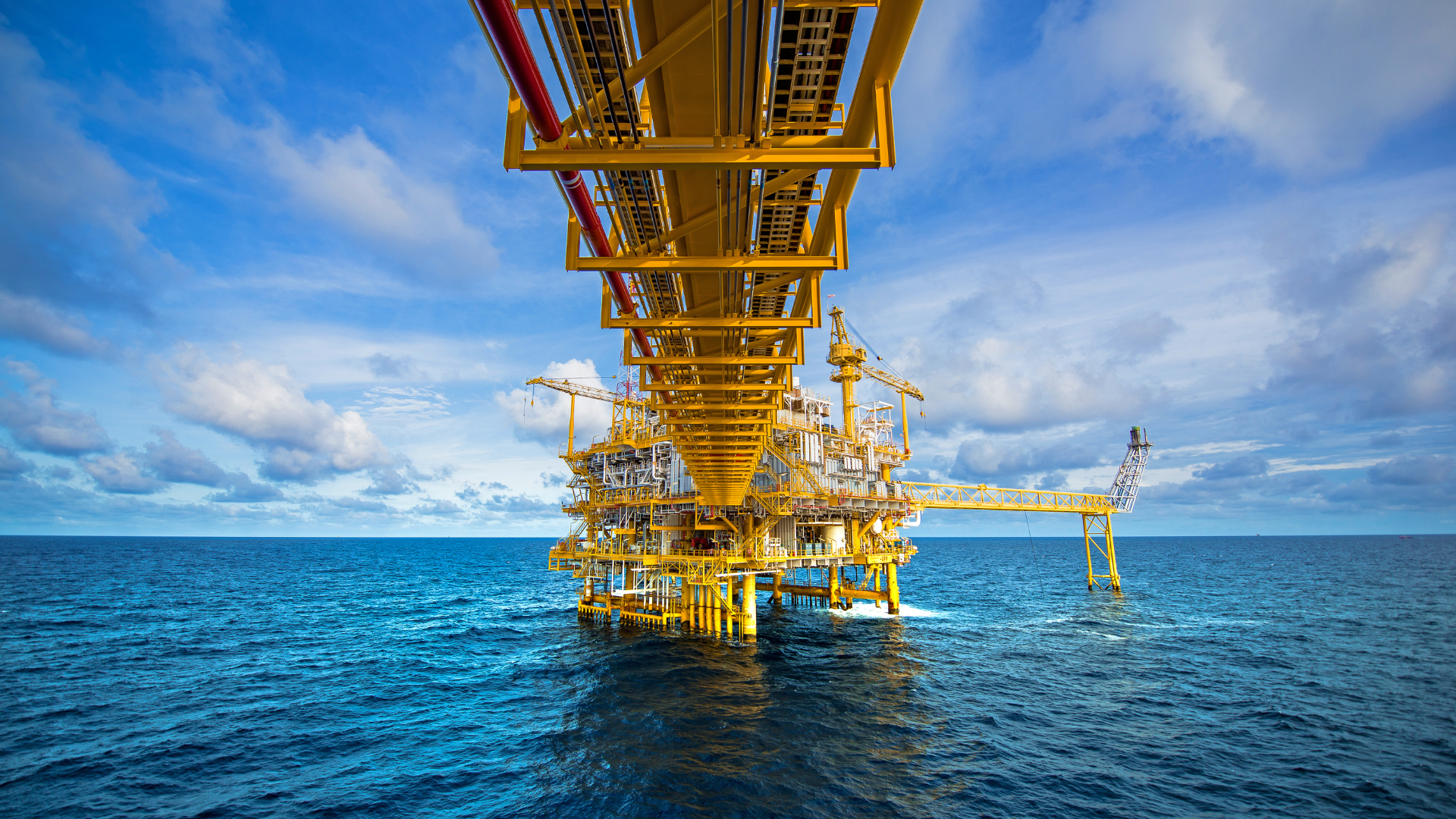La imagen muestra una plataforma petrolera offshore en un entorno marítimo, destacando su complejidad industrial y su integración con el paisaje natura