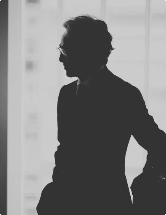 A man wearing a white safety helmet and a yellow high-visibility jacket with reflective stripes.