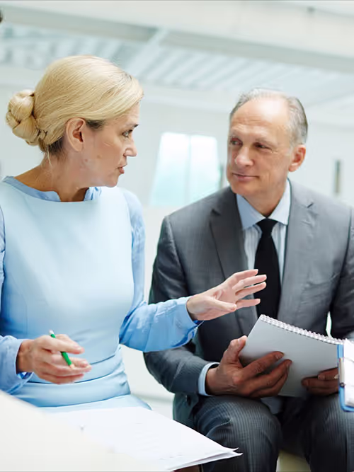 Business professionals engaged in a conversation, representing real-time interpretation services for legal, healthcare, and corporate settings.