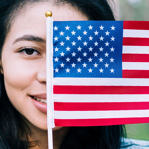 A multicultural individual holding an American flag, symbolizing language diversity and global communication.