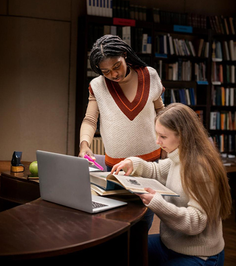 A teacher and student working together with a laptop, symbolizing multilingual education support through translation and interpretation services.