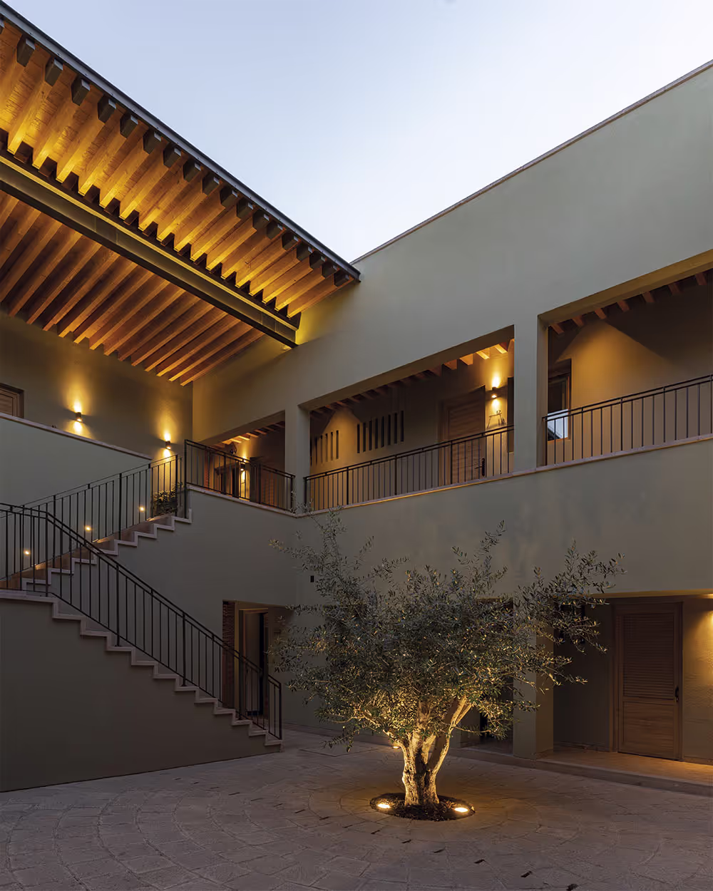 Patio del hotel Casa Aranzazu, con un árbol y escaleras.