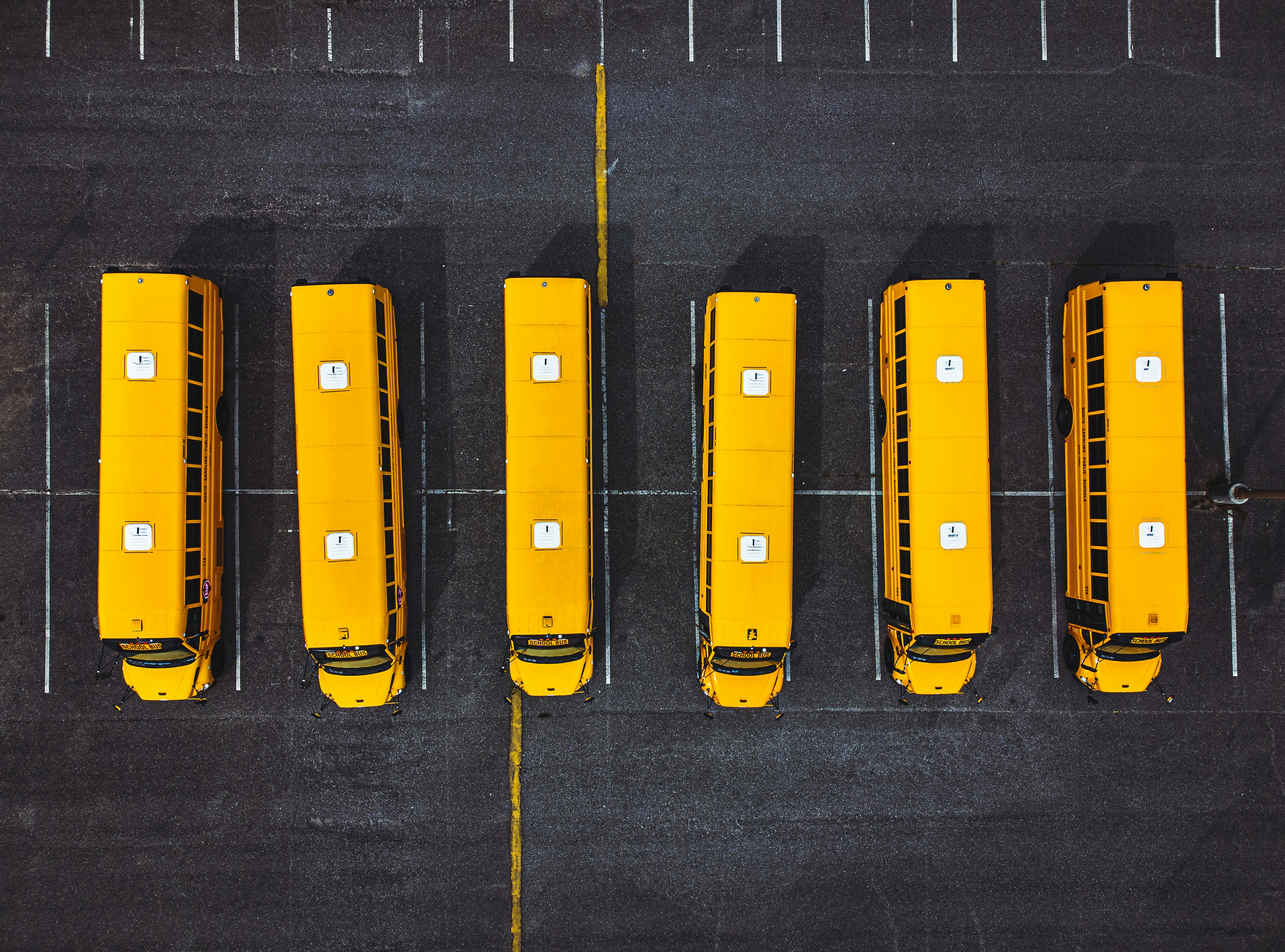 School buses parked outside a district facility illustrating captive insurance for schools and districts