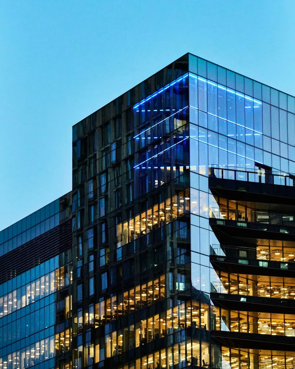 Modern glass office tower at dusk