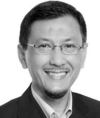 Portrait of a smiling man wearing glasses and a suit jacket with a collared shirt.