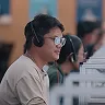 A man wearing a headset sitting in front of a computer.