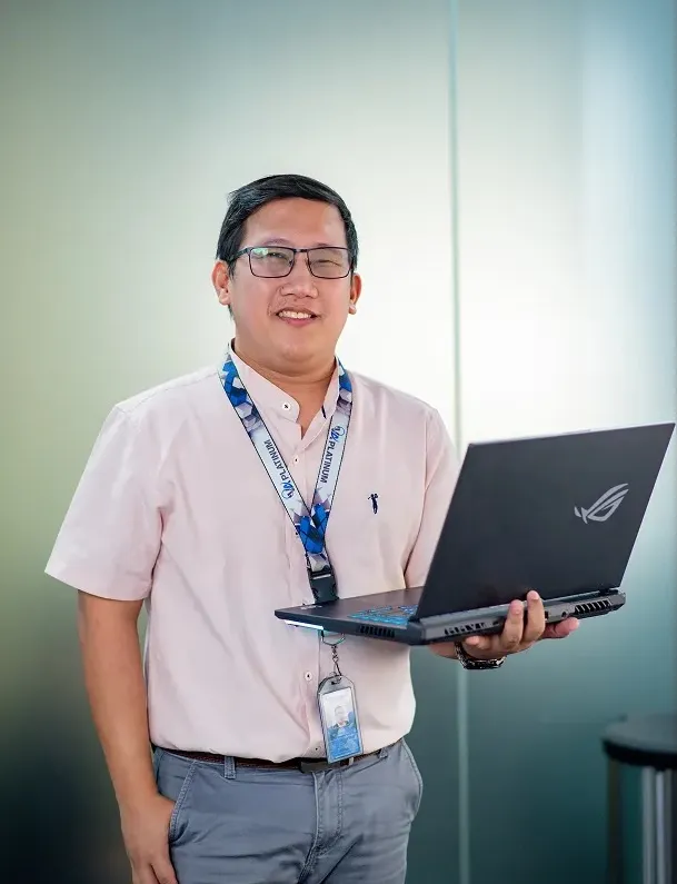 A man holding a laptop in his hands.