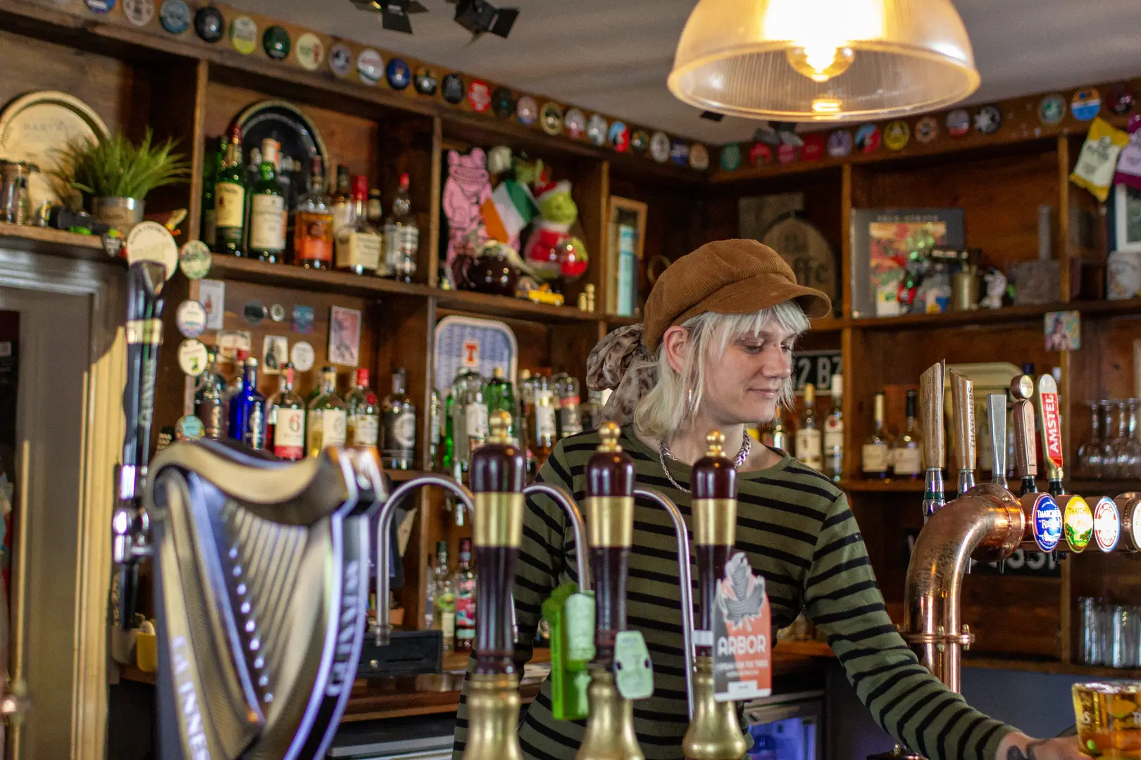 Smiling, happy barmaid serving a Thatchers in The George and Dragon pub, Redfield, Bristol 