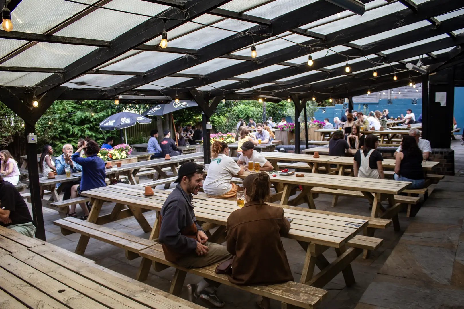 sheltered outside seating area with fairy lights and plenty of benches.