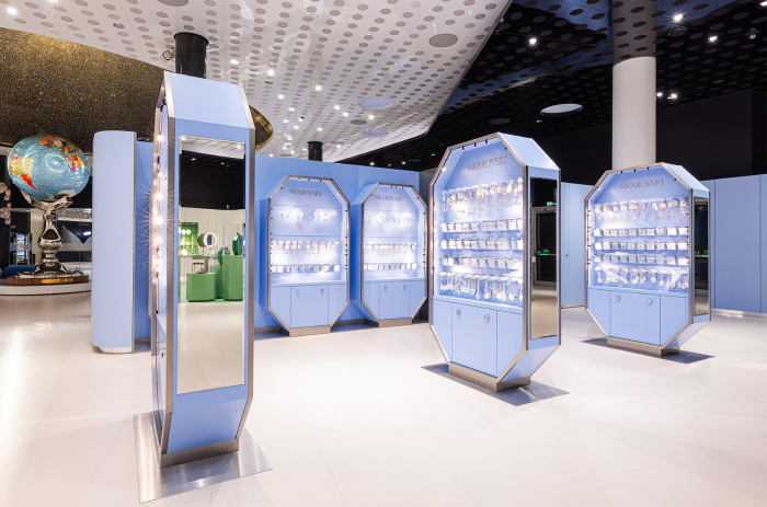 Moderner Swarovski Kristallwelten Store mit pastellfarbenen Auslagen und farbenfrohen Vitrinen.