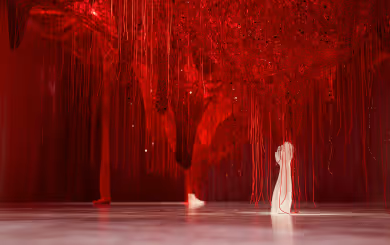 Wunderkammer Crystallizing Identity von Chiharu Shiota in den Swarovski Kristallwelten: Ein dichtes Netz aus roten Fäden mit eingearbeiteten Kristallen, aus dem eine weiße Kristallhand emporragt.