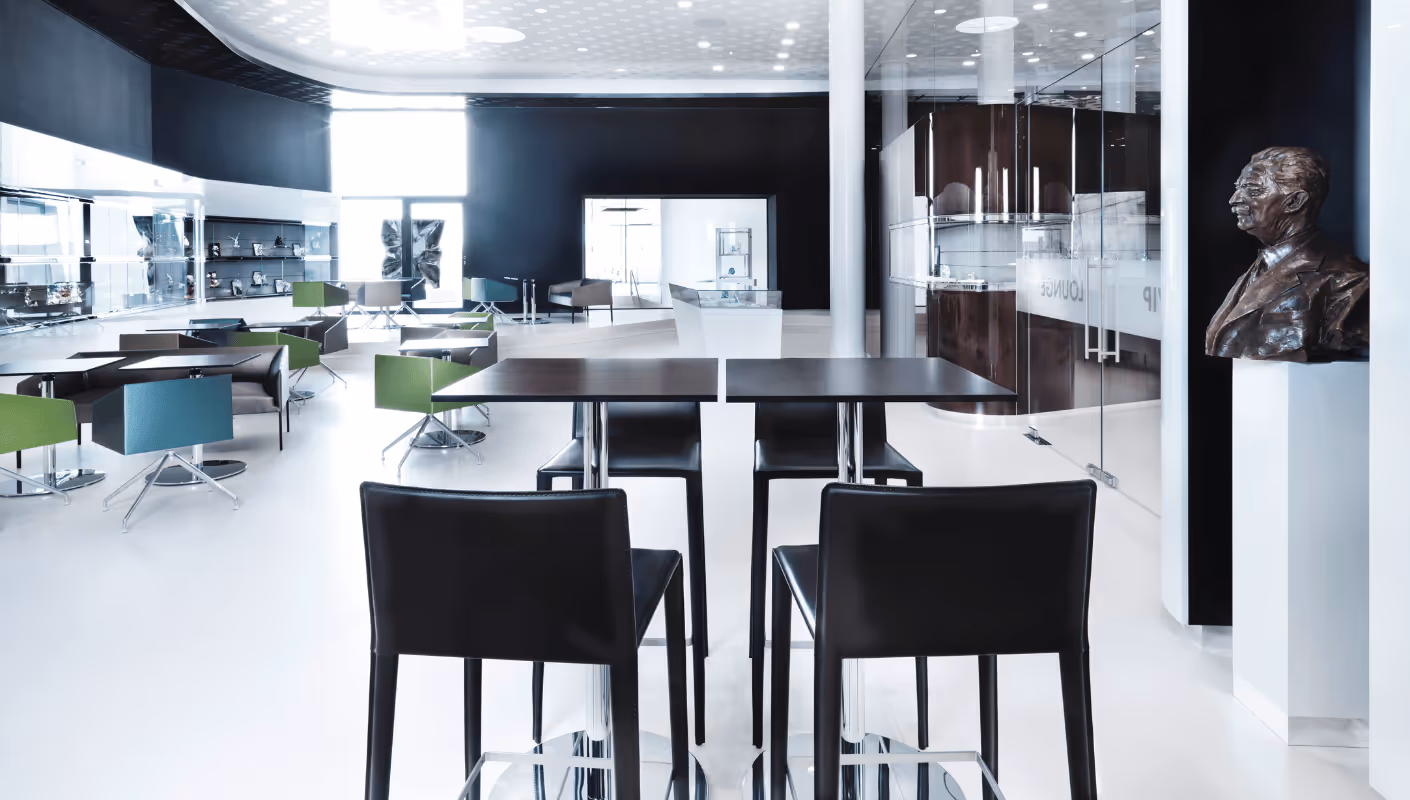 View of the elegant VIP lounge of Swarovski Kristallwelten with a modern seating area and sparkling crystal objects presented in brightly lit display cases.