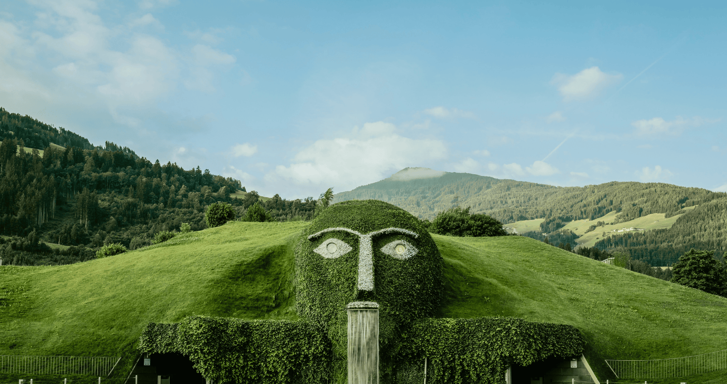 Der markante Riese mit leuchtenden Augen und Wasserfall ist das Herzstück der Swarovski Kristallwelten Wattens, umgeben von der Tiroler Bergkulisse.