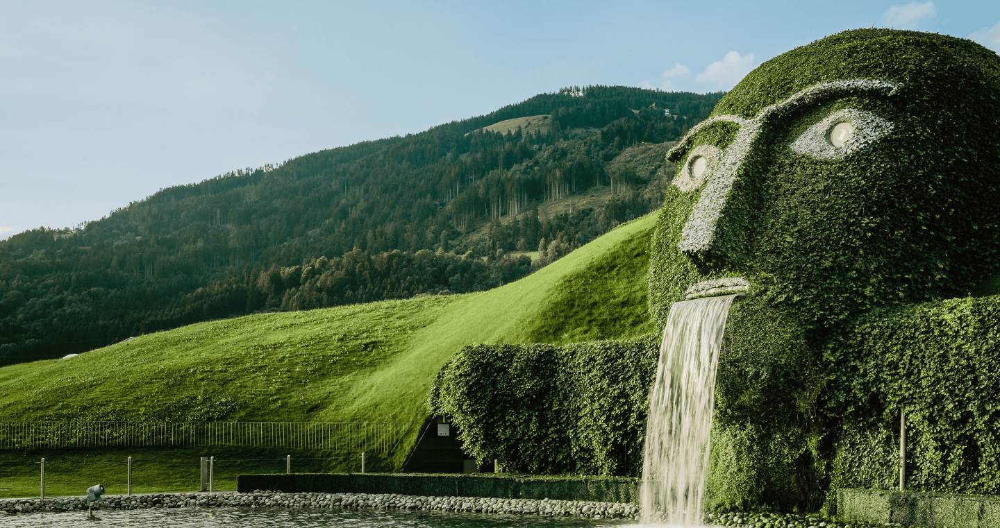 The iconic giant with glowing eyes and waterfall at Swarovski Kristallwelten Wattens, in the midst of the Tyrolean mountain landscape.