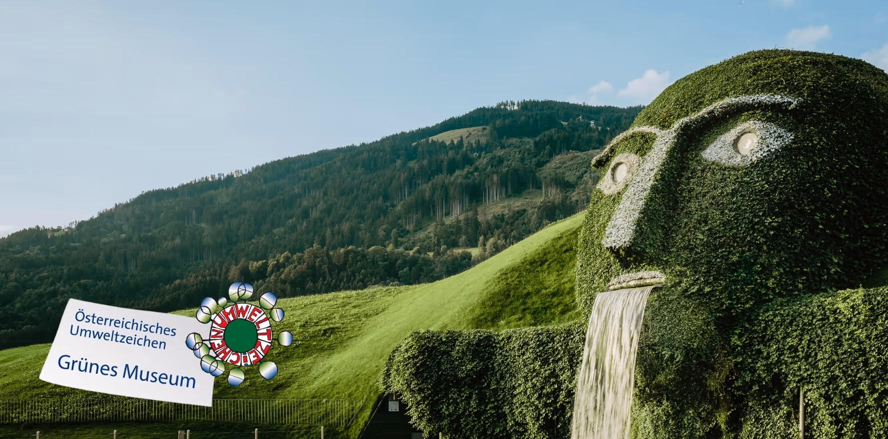 The iconic giant with glowing eyes and waterfall at Swarovski Kristallwelten Wattens, in the midst of the Tyrolean mountain landscape.