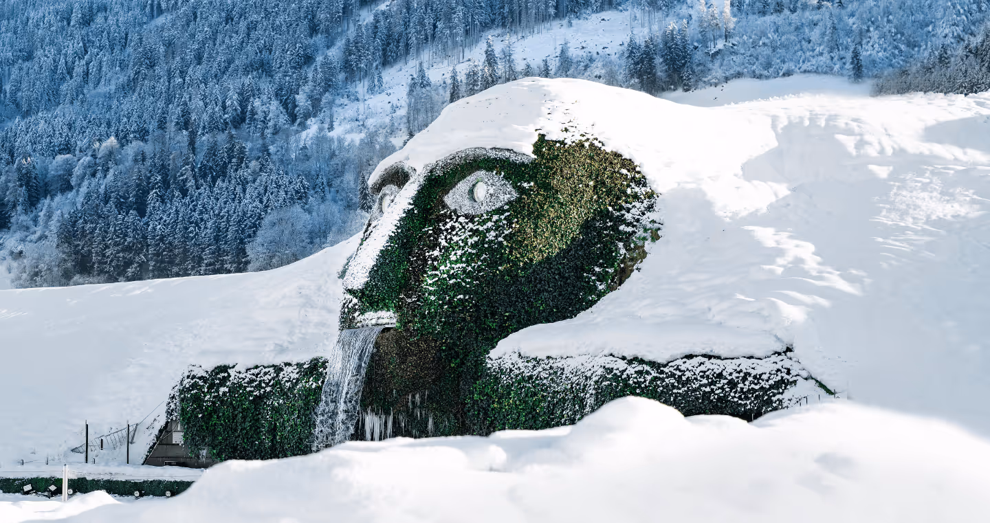 Der Riese der Swarovski Kristallwelten im Winter, bedeckt mit Schnee, umgeben von Tiroler Berglandschaft in Wattens.
