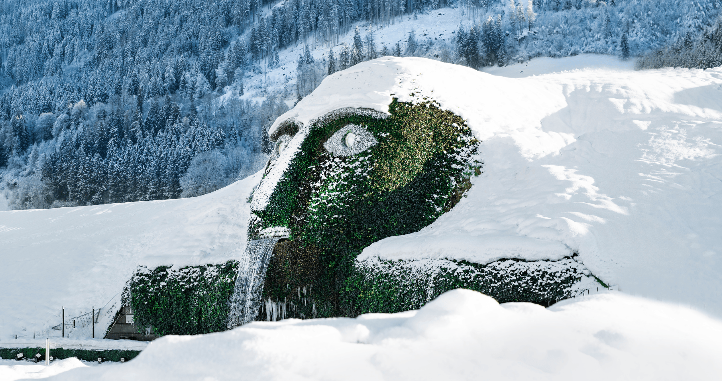 Der Riese der Swarovski Kristallwelten im Winter, bedeckt mit Schnee, umgeben von Tiroler Berglandschaft in Wattens.