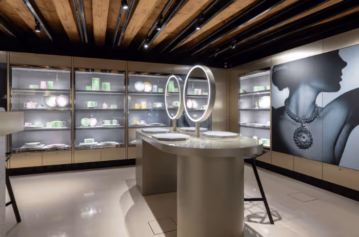 Innenansicht des Swarovski Kristallwelten Store Innsbruck mit farbenfrohen Vitrinen und modernen Schmuckpräsentationen in pastellfarbenen Auslagen.