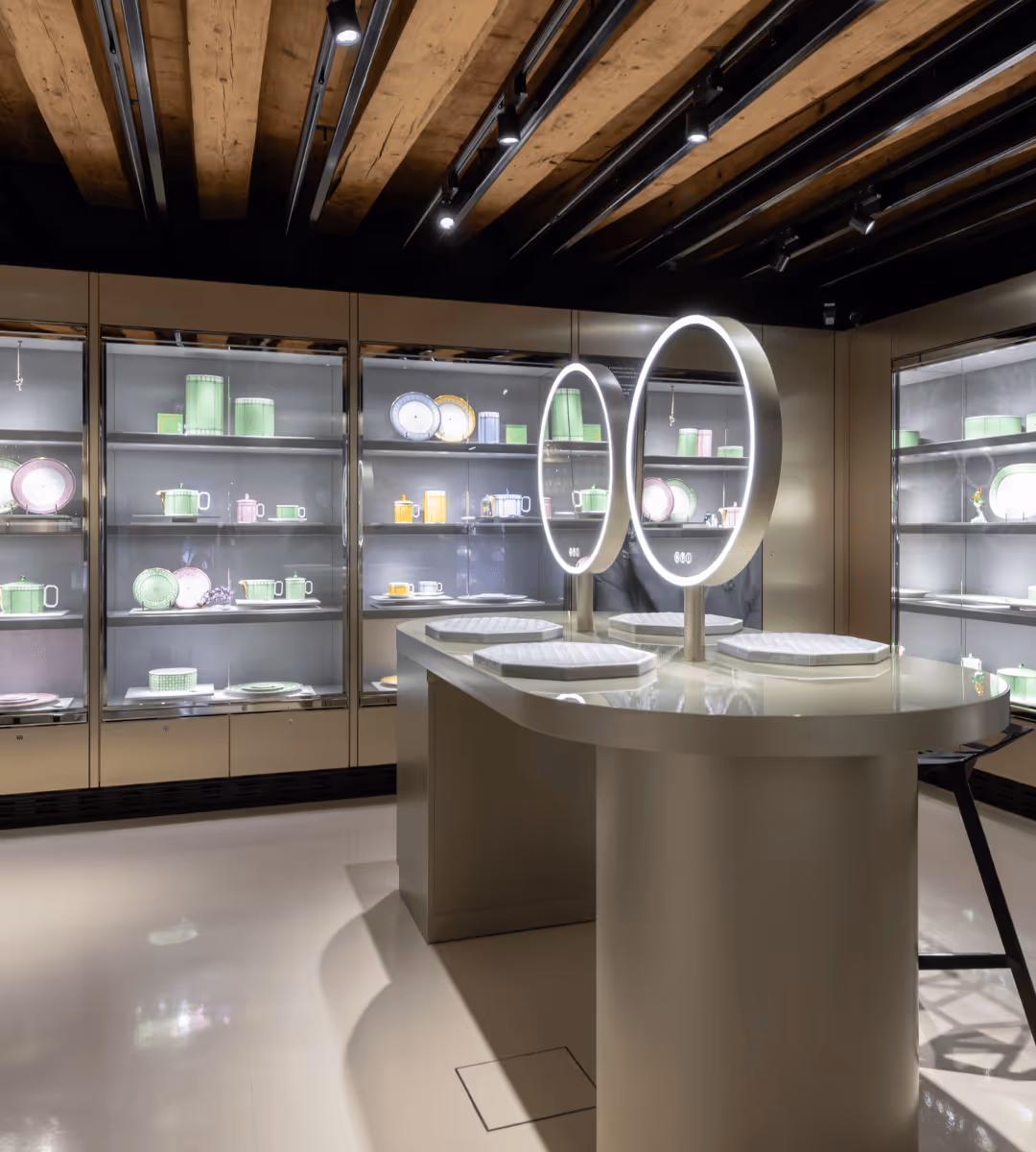 Innenansicht des Swarovski Kristallwelten Store Innsbruck mit farbenfrohen Vitrinen und modernen Schmuckpräsentationen in pastellfarbenen Auslagen.
