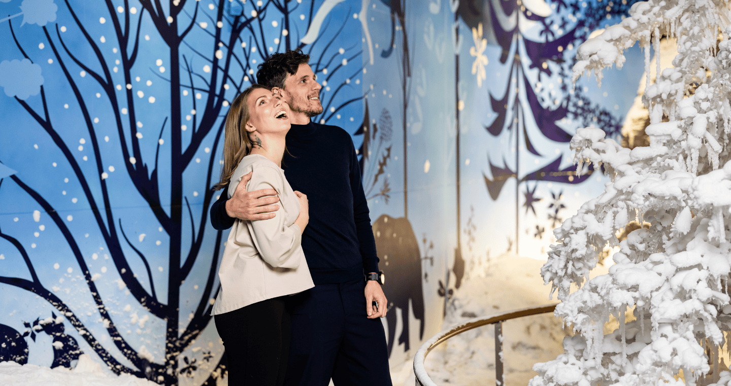 Ein Paar genießt die winterliche Stimmung in der Wunderkammer Silent Light in den Swarovski Kristallwelten – mit echtem Schneefall.