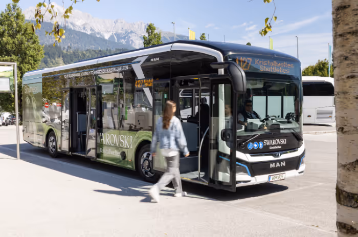 Moderner Swarovski Kristallwelten Shuttlebus mit E-Antrieb, bereit zur Abfahrt – nachhaltige Anreiseoption für Besucher*innen.