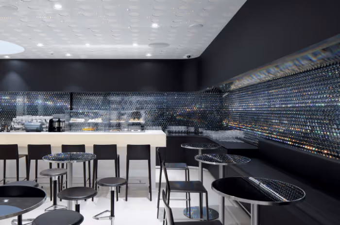 Crystal bar in the Swarovski Kristallwelten Store Wattens with white bar, sparkling wall and seating.