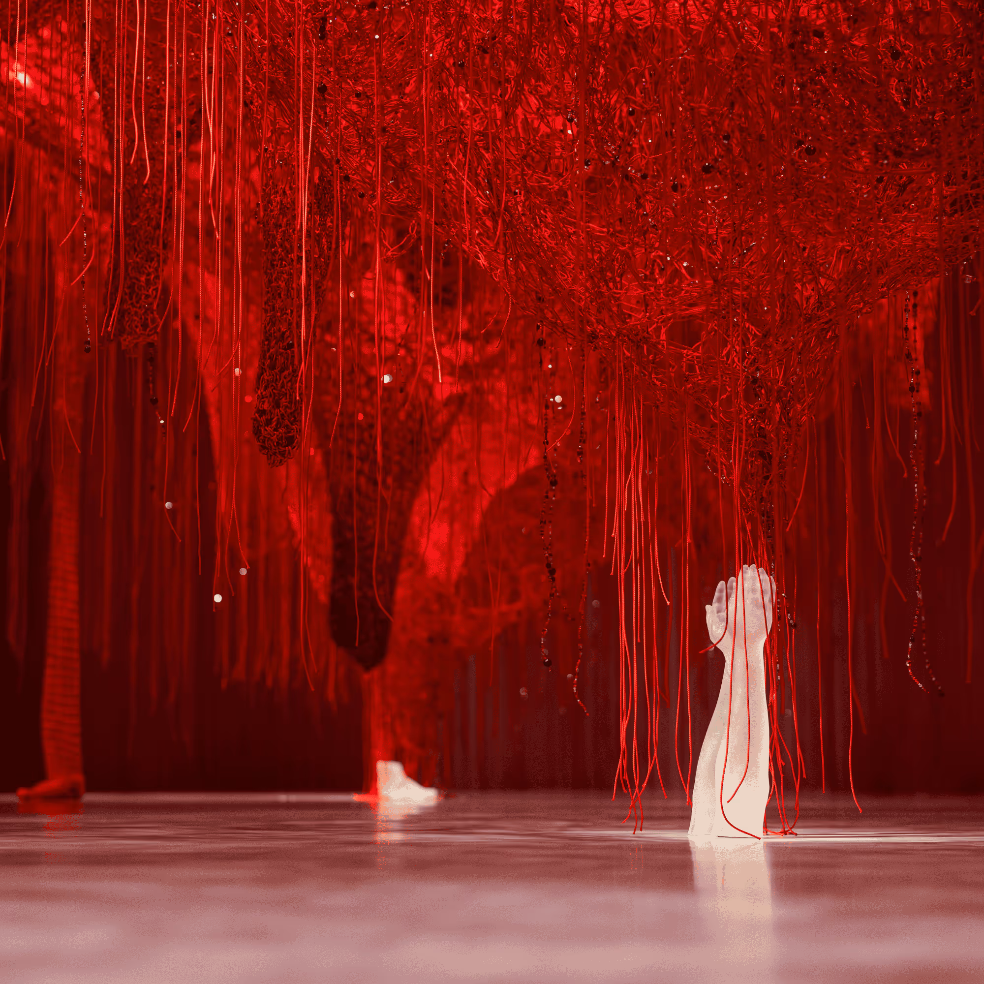 Chamber of Wonder Crystallizing Identity by Chiharu Shiota at Swarovski Kristallwelten: A dense network of red threads with incorporated crystals, from which a white crystal hand rises.