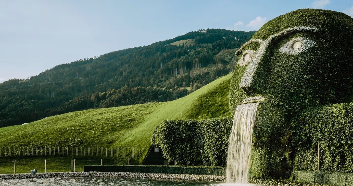 The iconic giant with glowing eyes and waterfall at Swarovski Kristallwelten Wattens, in the midst of the Tyrolean mountain landscape.