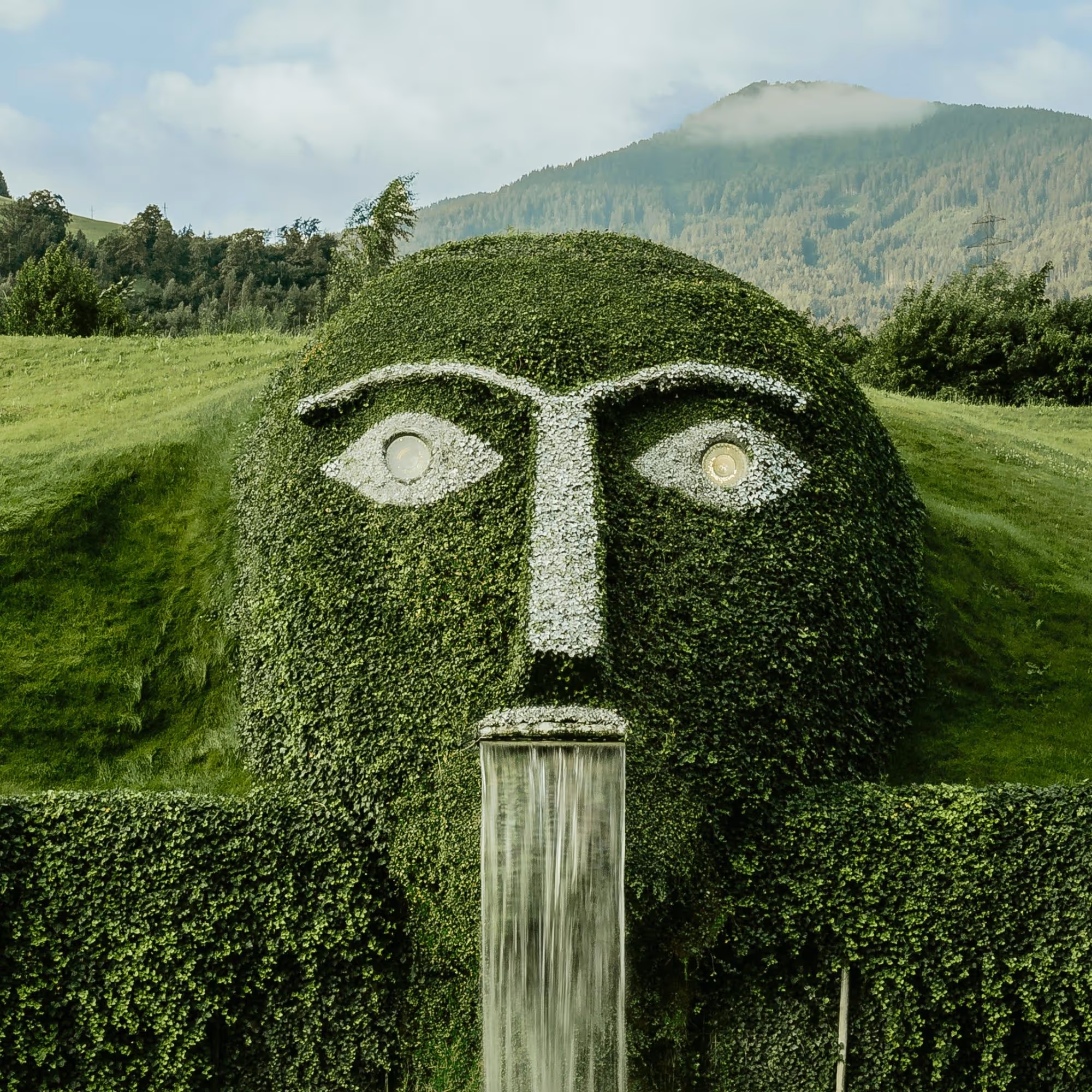 The distinctive giant with glowing eyes and waterfall at Swarovski Kristallwelten Wattens, surrounded by the Tyrolean mountain backdrop.