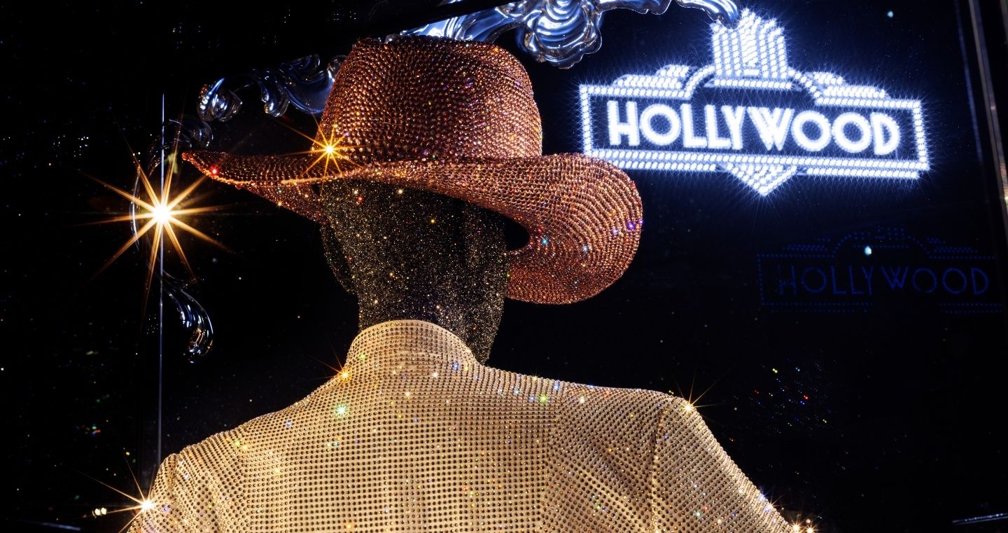 Chamber of Wonder Art of Performance at Swarovski Kristallwelten — sparkling costume installation with crystal-studded cowboy hat and jacket in front of glowing “Hollywood” lettering.