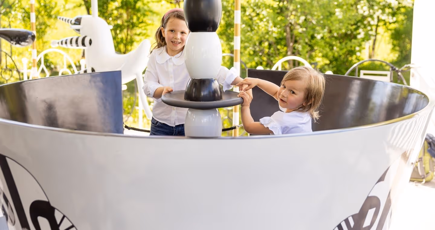 Two children play in the sparkling carousel at Swarovski Kristallwelten — fun for the whole family.