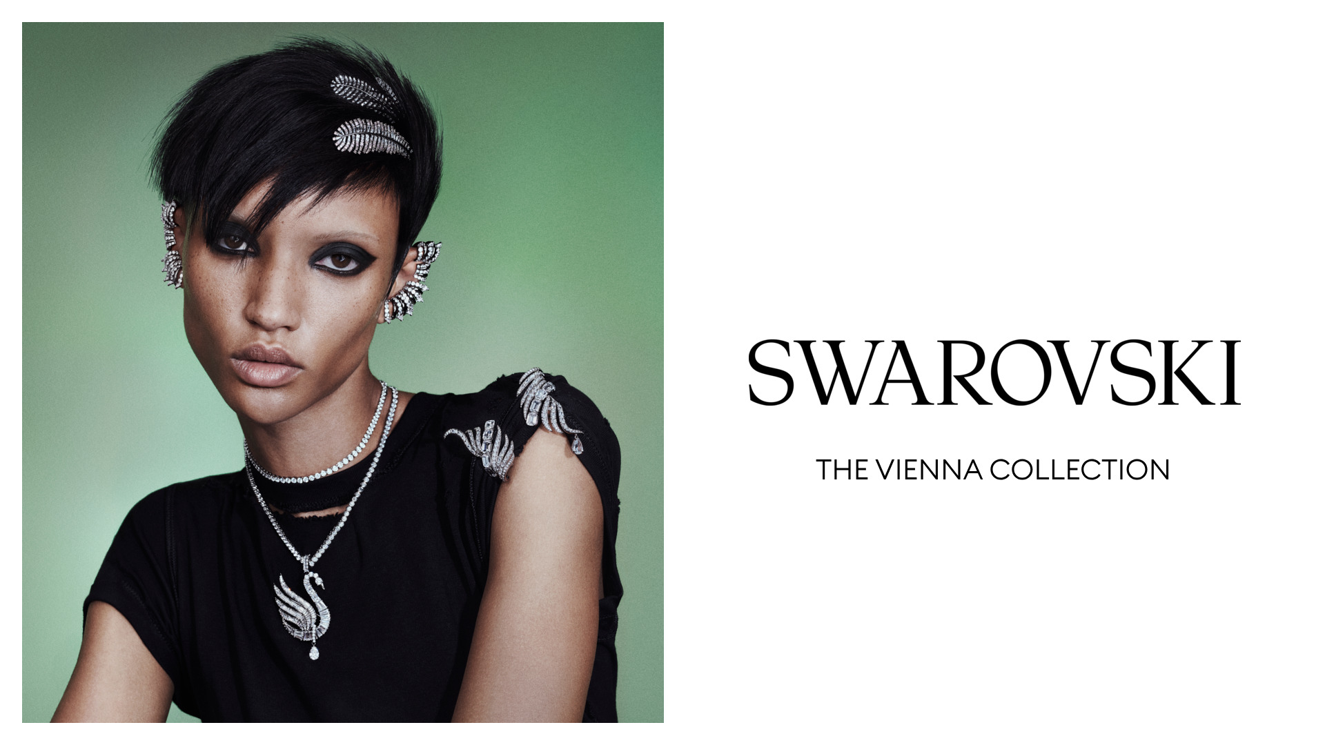 Model trägt funkelnde Schmuckstücke der Swarovski Vienna Collection – auffälliger Ohrschmuck, Ketten und Broschen mit Kristall-Details, präsentiert vor grünem Hintergrund mit Swarovski-Logo.