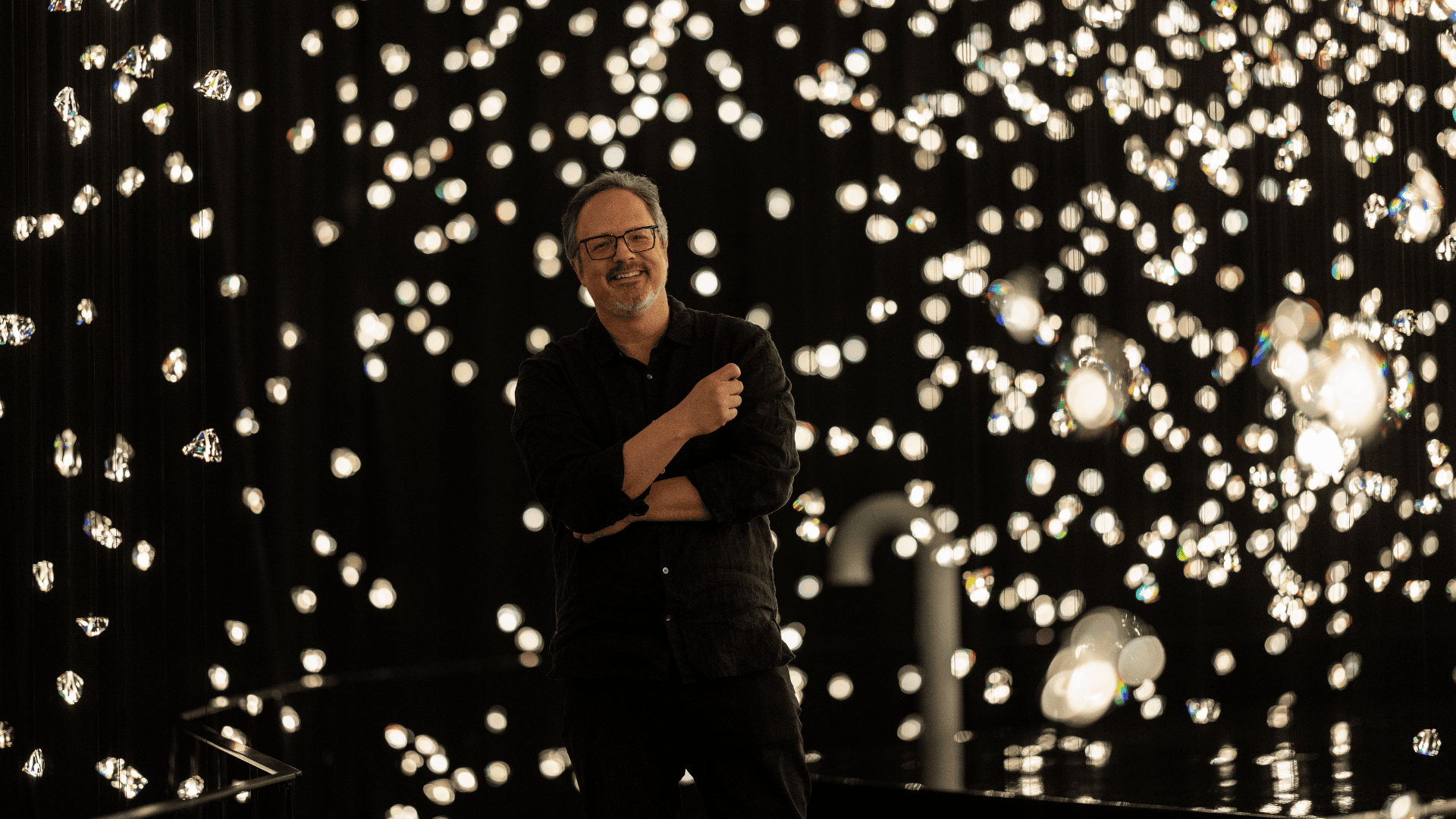 Artist Rafael Lozano-Hemmer in his Pulse Voronoi Chamber of Wonder at Swarovski Kristallwelten, surrounded by thousands of sparkling crystals.