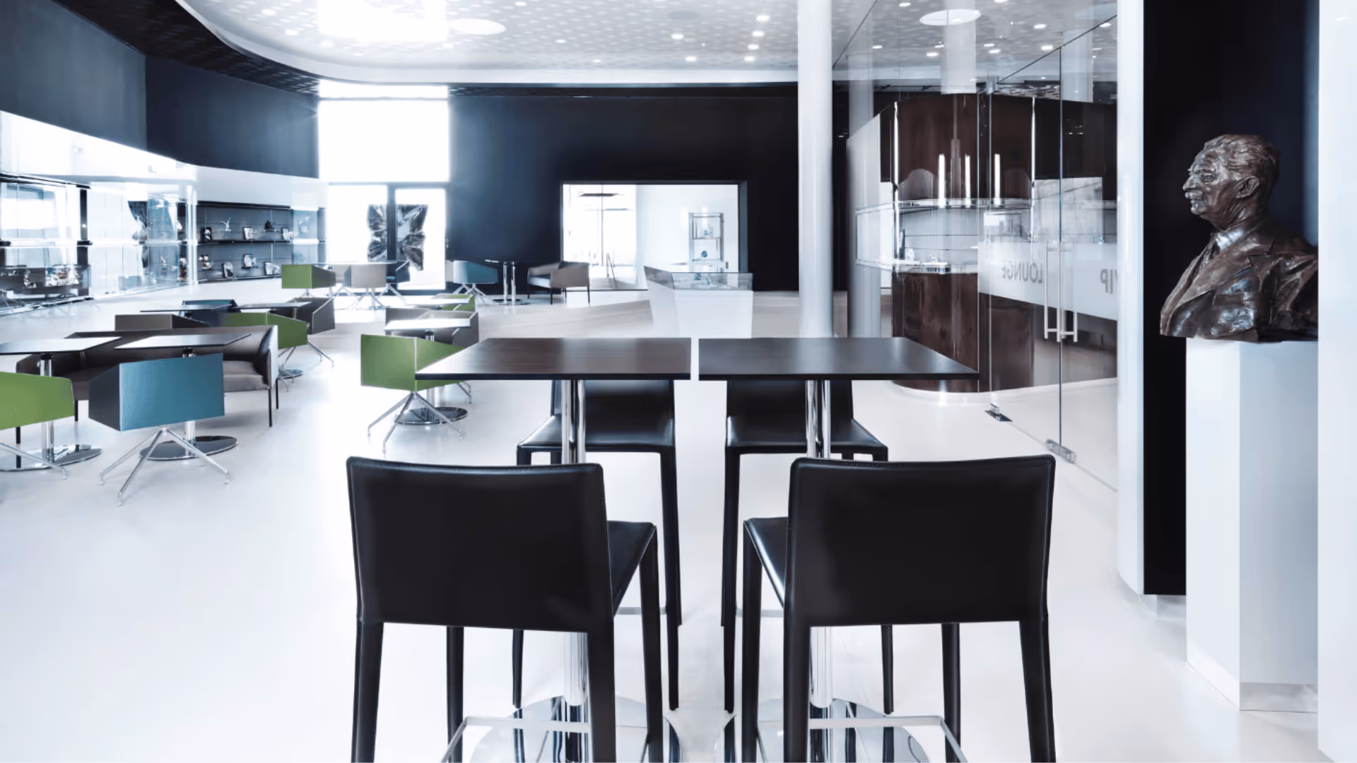 View of the elegant VIP lounge of Swarovski Kristallwelten with a modern seating area and sparkling crystal objects presented in brightly lit display cases.