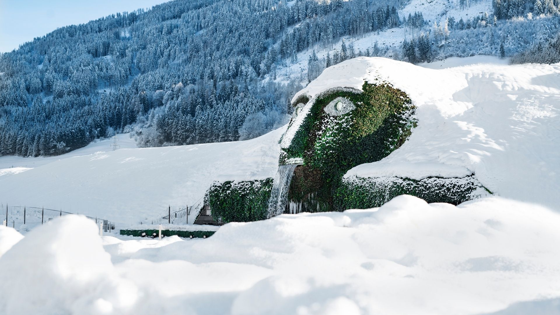 Der Riese der Swarovski Kristallwelten im Winter, bedeckt mit Schnee, umgeben von Tiroler Berglandschaft in Wattens.