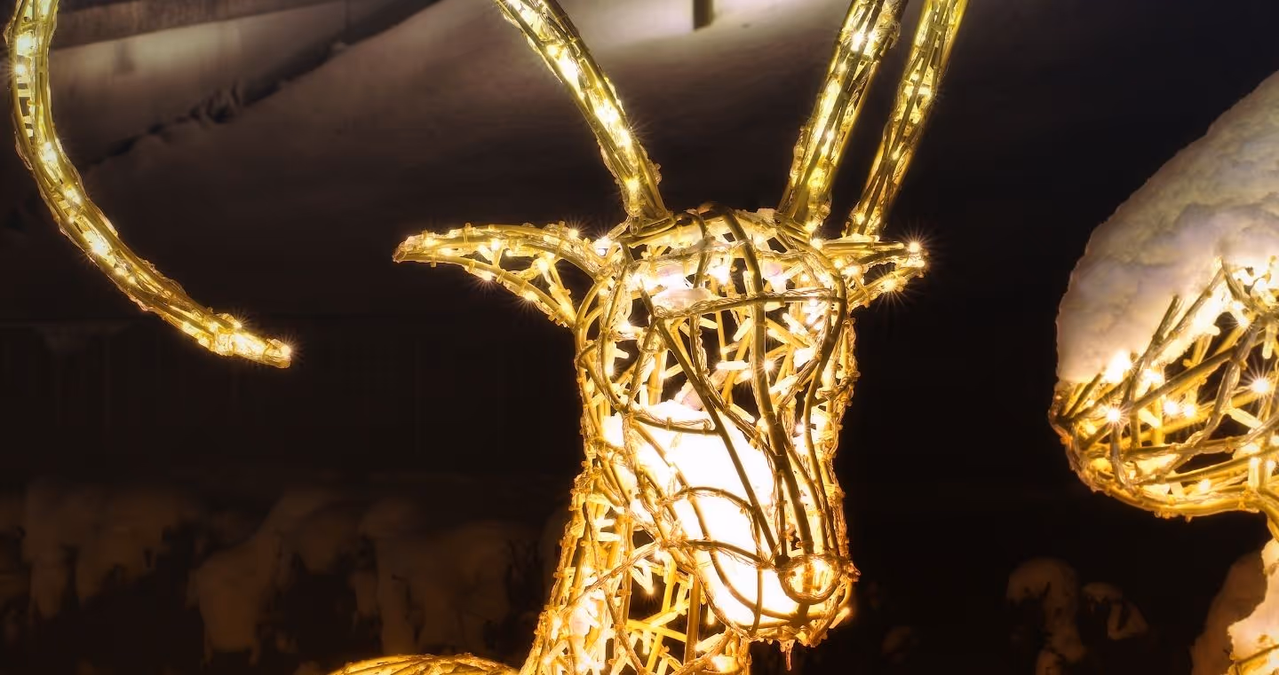 Illuminierte Tierfigur mit langen Hörnern in winterlicher Parklandschaft des Winter Wonderland der Swarovski Kristallwelten.