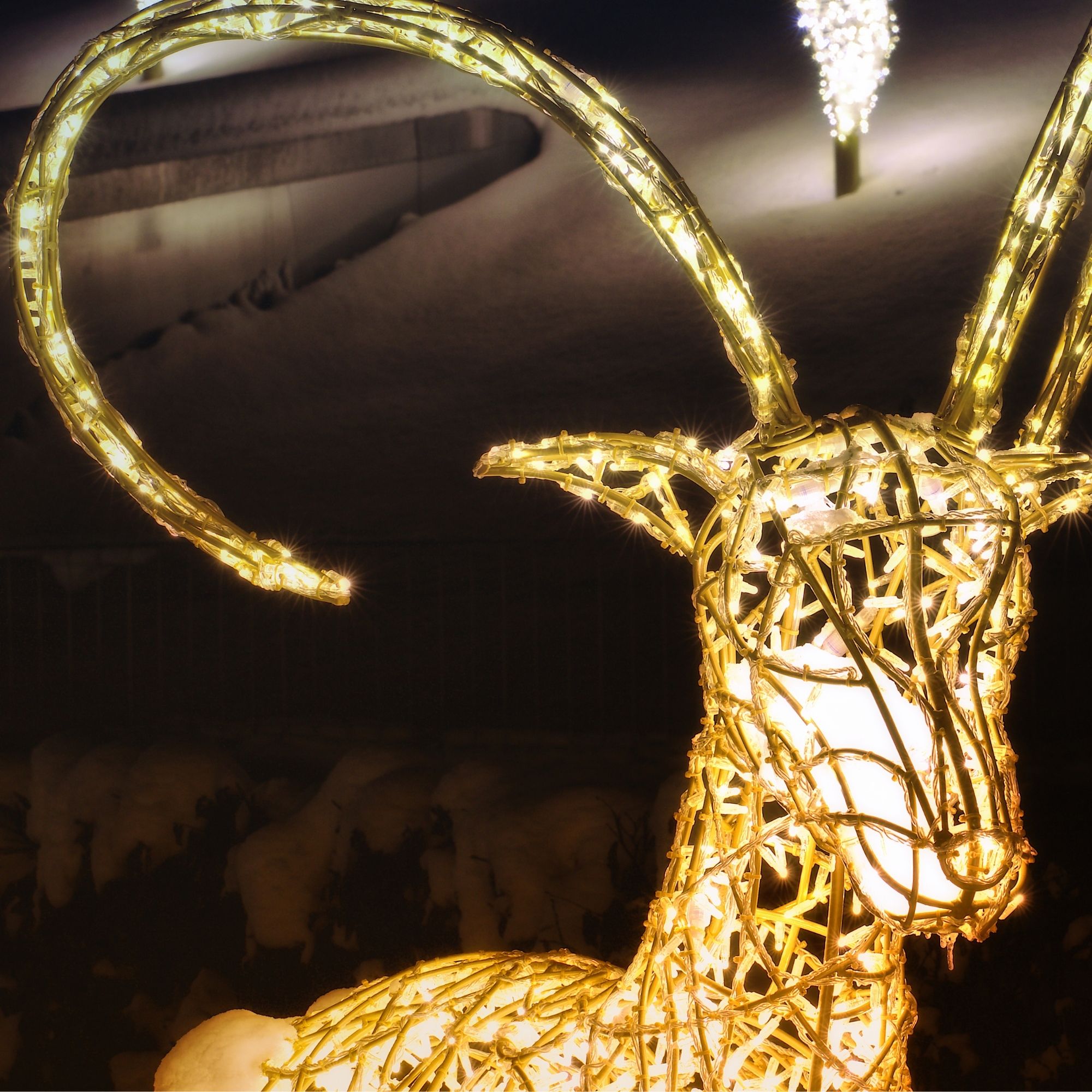Illuminierte Tierfigur mit langen Hörnern in winterlicher Parklandschaft des Winter Wonderland der Swarovski Kristallwelten.