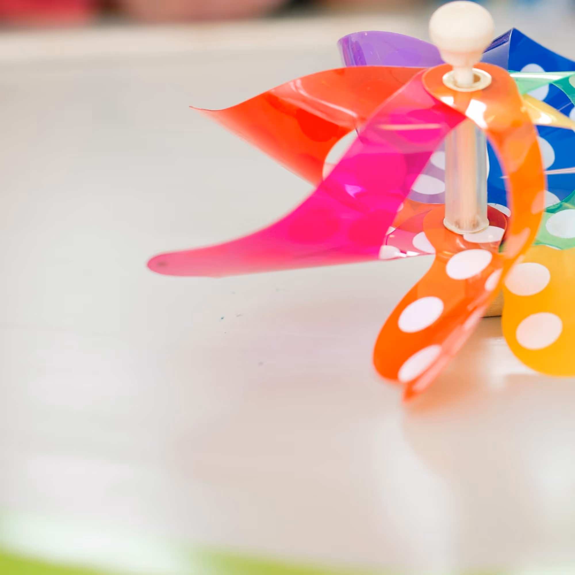 Children's hands make a colorful wind turbine with white dots during a children's program at Swarovski Kristallwelten.