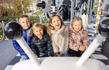 Happy kids enjoy a carousel ride during a Swarovski Kristallwelten birthday program.